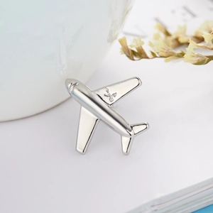Minimalist silver airplane brooch pin in polished alloy displayed on aesthetic background