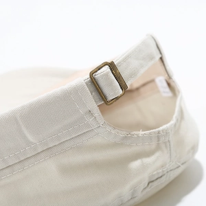 Detailed close-up of khaki cotton military cap featuring adjustable vintage copper buckle