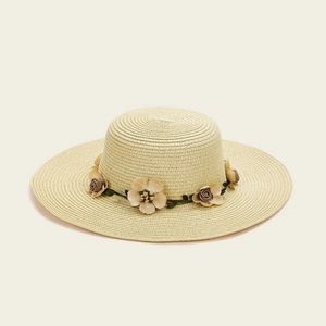 Detailed top view of a wide-brim straw sun hat featuring 3D floral band decorations