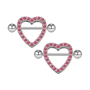 Close-up of heart-shaped stainless steel nipple rings with pink rhinestones set on white