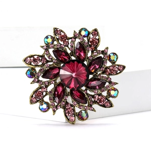 Macro detail of vintage floral brooch with purple rhinestones and crystal accents