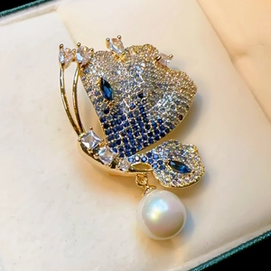 Luxurious gold butterfly brooch with blue crystals and white natural pearl drop