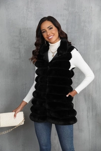 Détail d'un long gilet en fausse fourrure noire avec fermeture éclair fluide