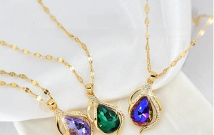 Detail of waterdrop crystal necklaces in purple, green, and blue with zircon setting