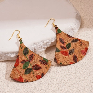 Détail de boucles d'oreilles en liège en forme d'éventail aux motifs de feuilles rouges et vertes