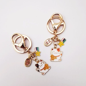 Japanese Maneki Neko lucky cat keychain in gold metal with fortune charms and colorful star