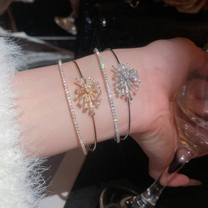 Detail of gold and silver firework bracelets with pearls and zircons on a model's wrist