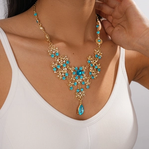 Vintage gold necklace set with hollow floral patterns and blue teardrop crystal pendants