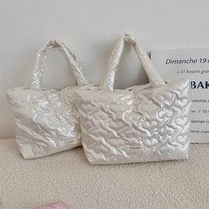 Detail of white quilted lunch bags with heart and bow patterns and Sezakka brand label