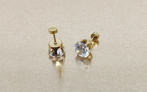 Macro view of 18k gold-plated 6-claw earring studs with round cubic zirconia stones