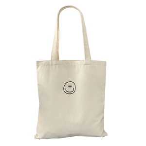 Minimalist canvas tote bag with black smiley face print for daily casual use