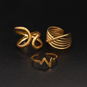 Detailed view of three gold-tone stainless steel rings featuring wave and tiered designs
