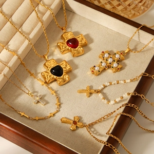 Detailed view of assorted stainless steel cross necklaces and bracelets in a wooden tray