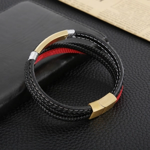 Detail of multi-layer braided leather bracelet with gold magnetic clasp on vintage pages