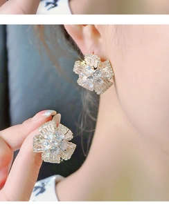 Detailed macro view of silver flower stud earrings with sparkling cubic zirconia crystals