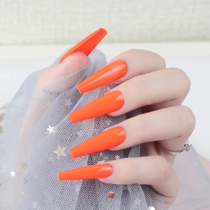 Detail of bright orange long coffin press-on nails with a high-gloss UV finish surface