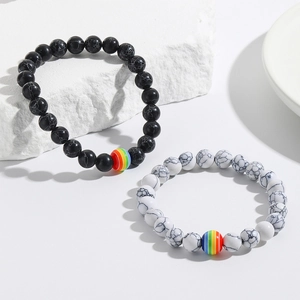 Detailed macro of black and white marble bead bracelets with rainbow stripe center beads