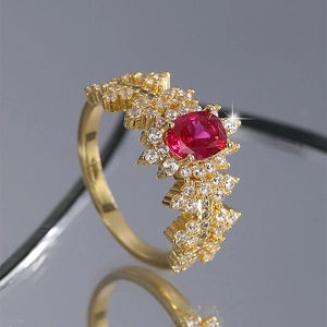 Elegant gold ring with oval red gemstone and white zircon accents on mirror base