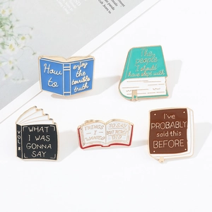 Detailed view of 5 colorful enamel book pins with humorous English quotes on white desk