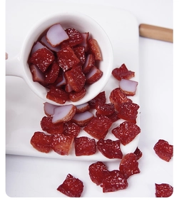 Macro detail of miniature PVC smoked meat cubes with realistic oily texture and red color