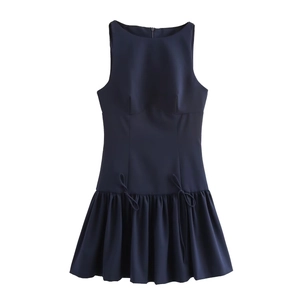 Detail shot of the navy blue sleeveless dress featuring dual bow ties and pleated hemline