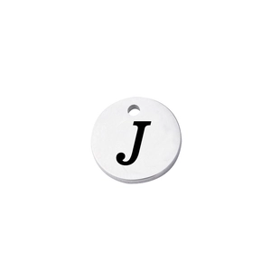 Close-up of polished silver stainless steel round pendant with engraved capital letter J