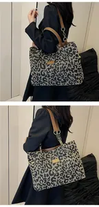 Detail of leopard jacquard tote with brown leather strap and golden hardware rings