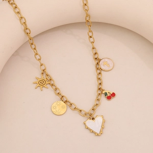 Dettaglio collana dorata con ciondoli a cuore bianco, ciliegia, sole e stella tonda