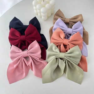 Detailed display of large fabric bow hair clips in seven colors with high density texture