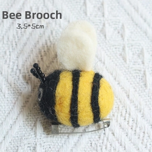 Macro detail of handmade wool felt bee brooch with metal safety pin, 3.5x5cm size