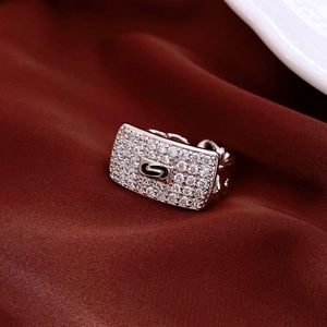 Macro shot of silver-tone cuban chain ring with zircon rectangle and black S logo