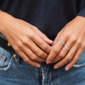 Close-up of minimalist S925 sterling silver triple cross layered open ring on hand
