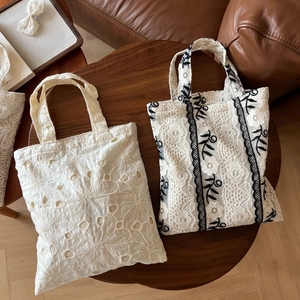 Detailed macro view of French vintage lace embroidery patterns on small tote bags