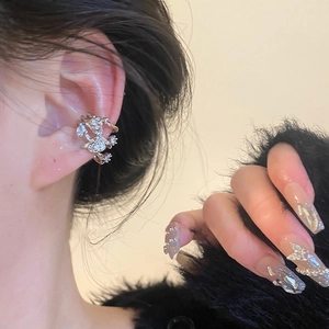 Close-up of elegant silver flower ear cuff with zircon crystals on a female ear
