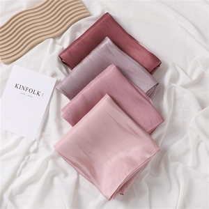 Detail of soft satin scarves in pink gradient shades with silky smooth texture