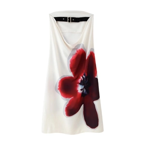 Detail of white maxi dress showing red floral print and black buckle on the neckline