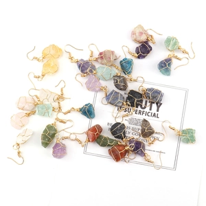Detail view of handmade gold wire-wrapped natural raw stone earrings in various colors