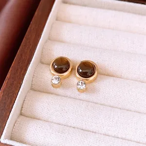 Vintage round amber resin earrings with gold alloy and zircon on a jewelry tray