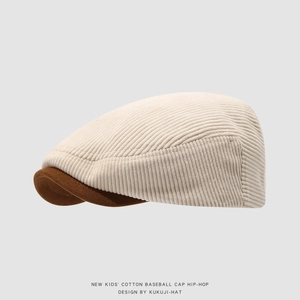Detail van de corduroy baret voor kinderen met beige stof en bruine suède randtextuur