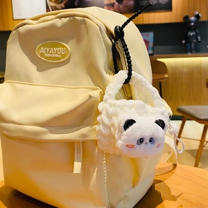 Light yellow fashion backpack with a cute white panda plush pendant in a cafe setting