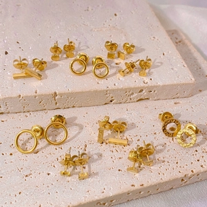 Detailed view of assorted gold geometric stud earrings with hammered textures on stone.
