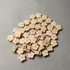 Détail de perles de fleur de prunier en buis sculpté pour création de bijoux DIY