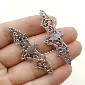 Detailed view of silver hollow bat pendants for DIY jewelry and Halloween accessories