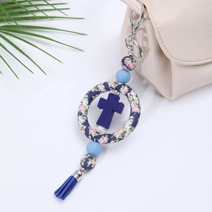 Detail of blue silicone cross keychain featuring stylish beads and a long decorative tassel