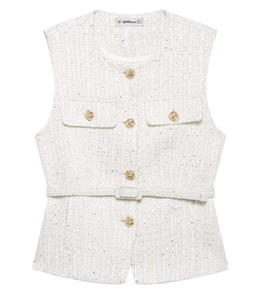 Close-up of cream tweed vest featuring gold corded buttons and matching belted waist detail
