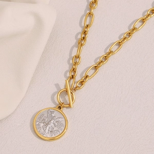 Detailed close-up of 18K gold chunky chain necklace with silver angel coin pendant and OT clasp