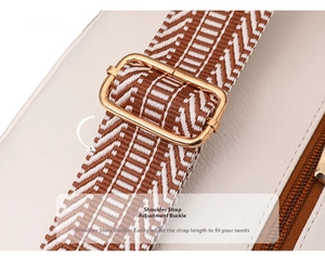 Detail of adjustable gold buckle on geometric woven strap for cream leather chest bag