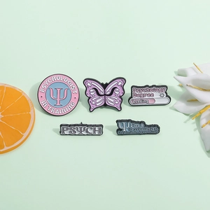 Psychology enamel pin set featuring butterfly and letters on a soft green background