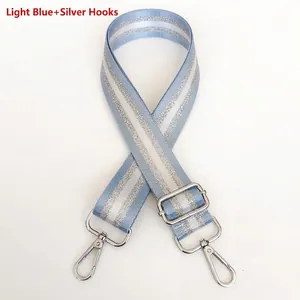 Close-up of light blue and silver striped nylon bag strap with silver metal hooks
