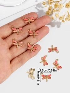 Detail of dragonfly alloy pendant with orange-pink enamel and size measurements